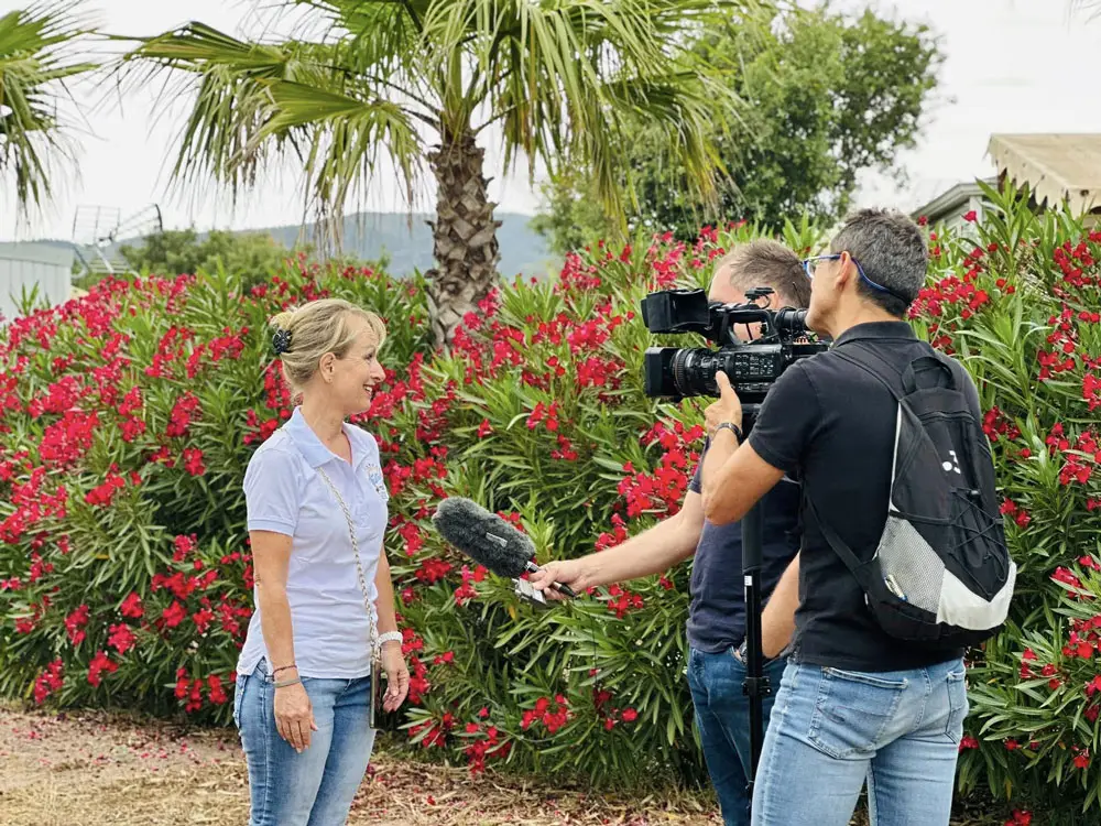 Sabine, a key figure at Esterel Caravaning, interviewed by a television crew at the campsite