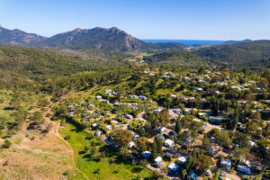 Aerial view of the Esterel Caravaning estate in Agay, its pitches beneath the pines, the Esterel massif and the sea on the horizon